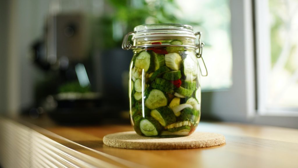 Green and Clear Glass Jar on Brown Wooden Table