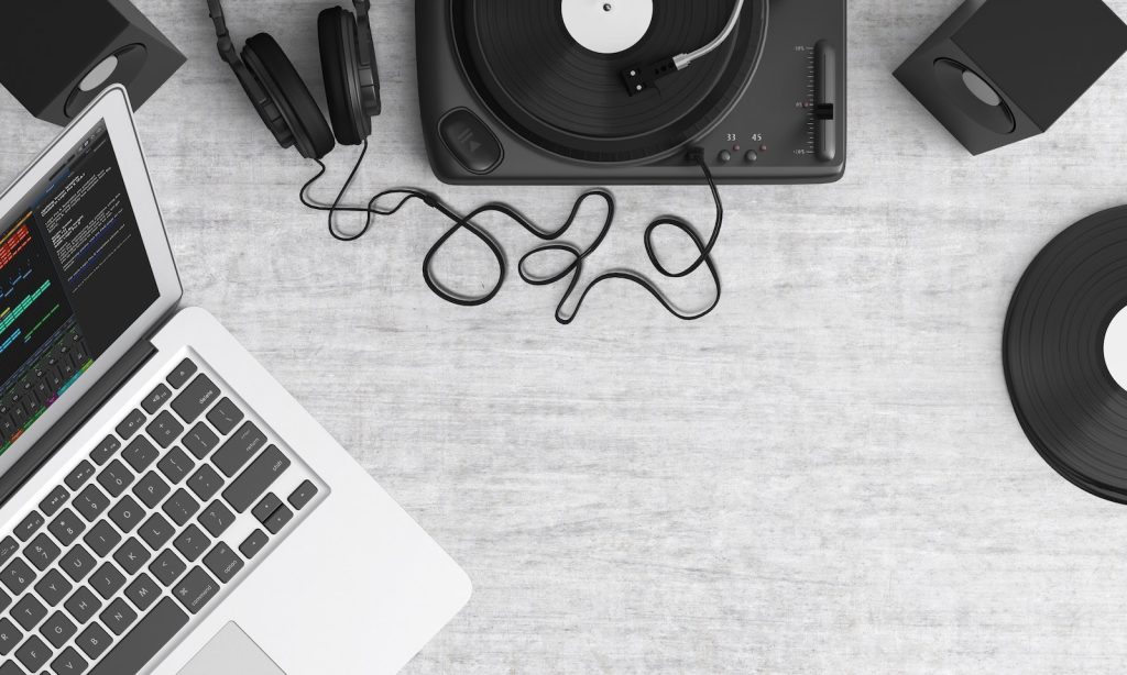 Macbook Pro Beside Black Headphones on Gray Table