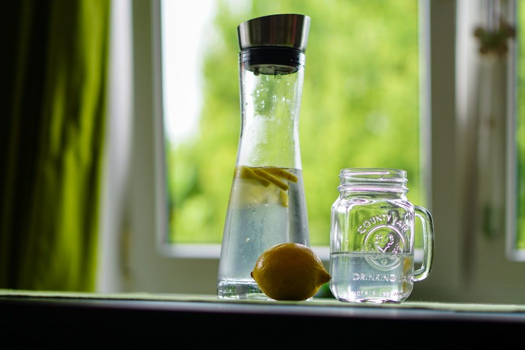 Shallow Focus Photography of Yellow Lemon Near Glass Mason Jar and Glass Decanter