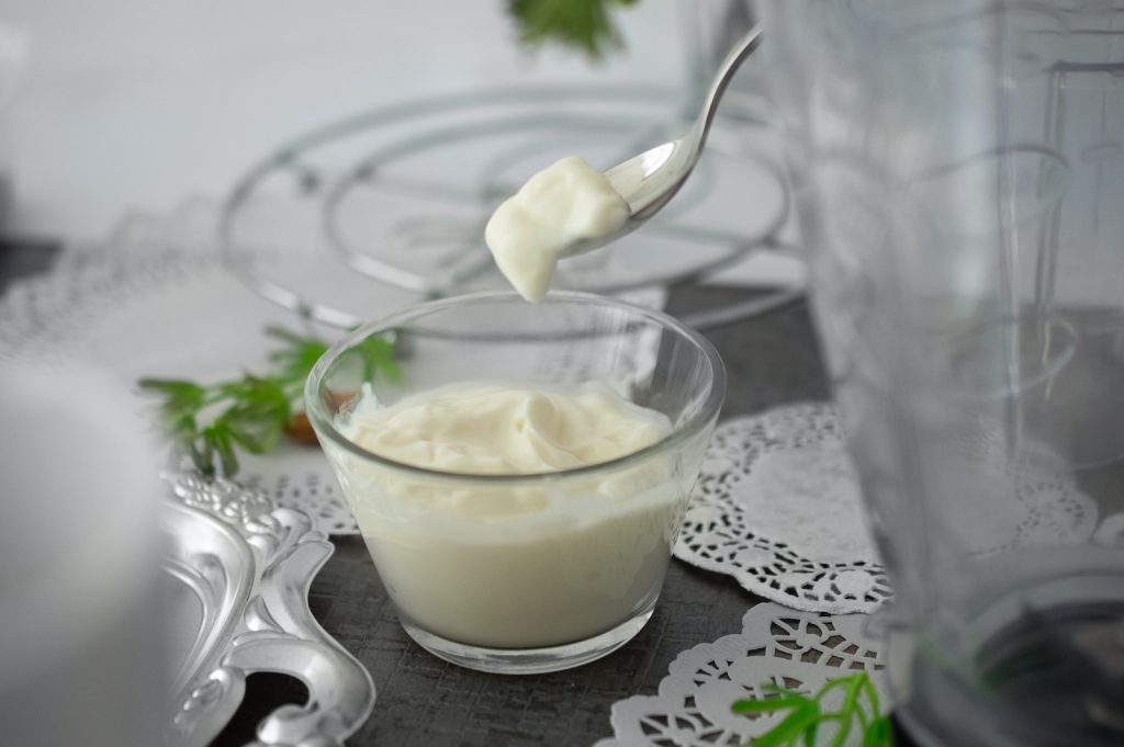 close-up photo of white cream in clear shot glass