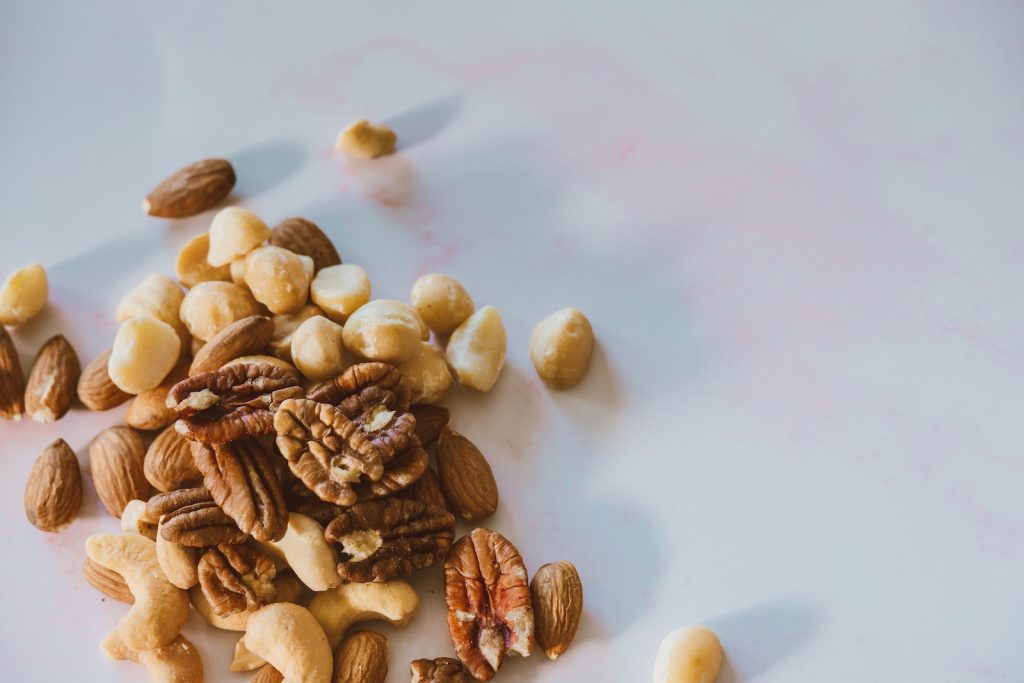 Close-Up Shot of Assorted Nuts on a White Surface