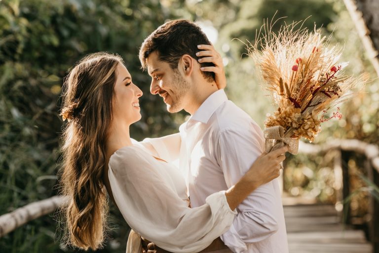 man in white dress shirt holding brown flower bouquet