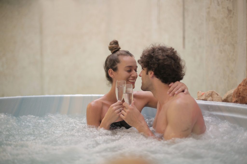 Happy couple having fun in jacuzzi during romantic date