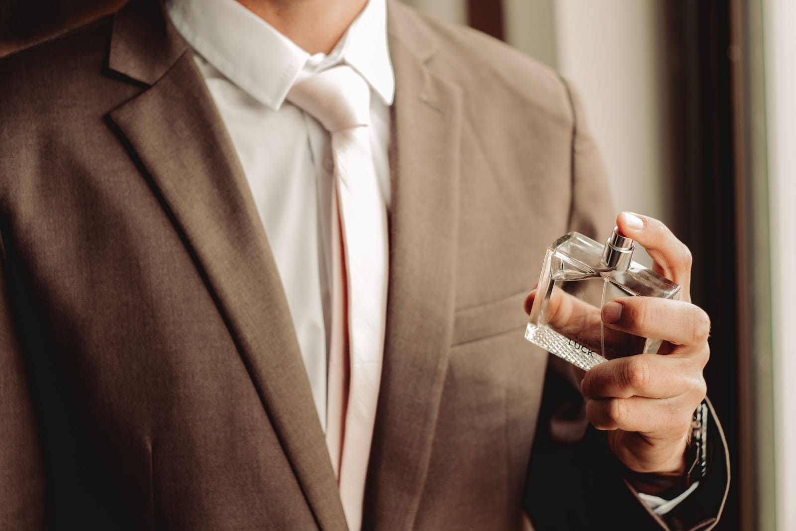 Man Wearing Suit and Necktie with Perfume Bottle