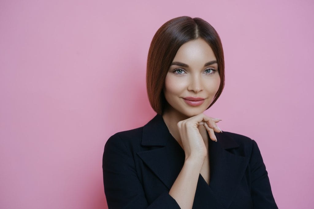 Positive woman near pink wall