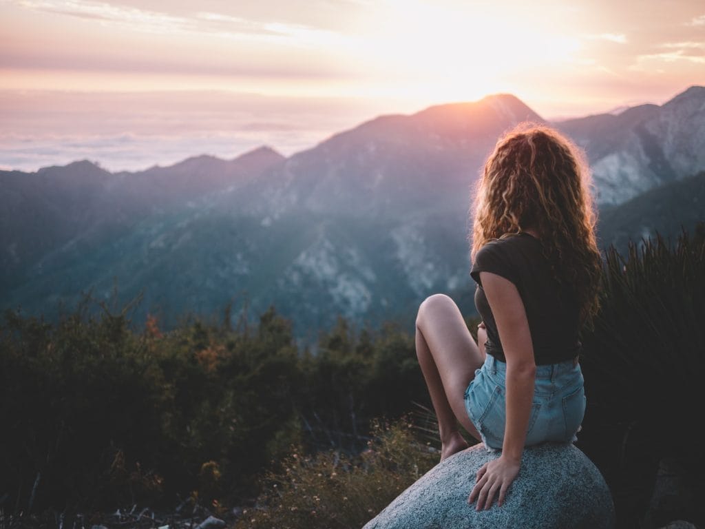 woman sitting on rock