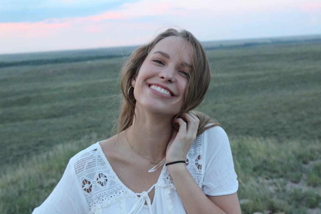 woman smiling while taking photo during daytime