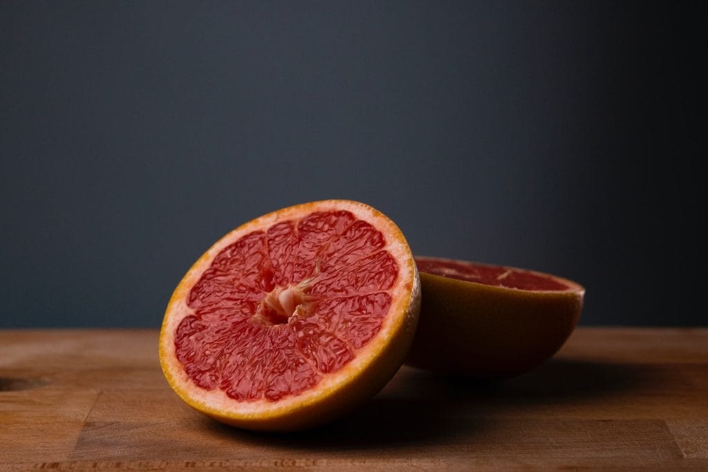 sliced orange fruit on brown wooden table