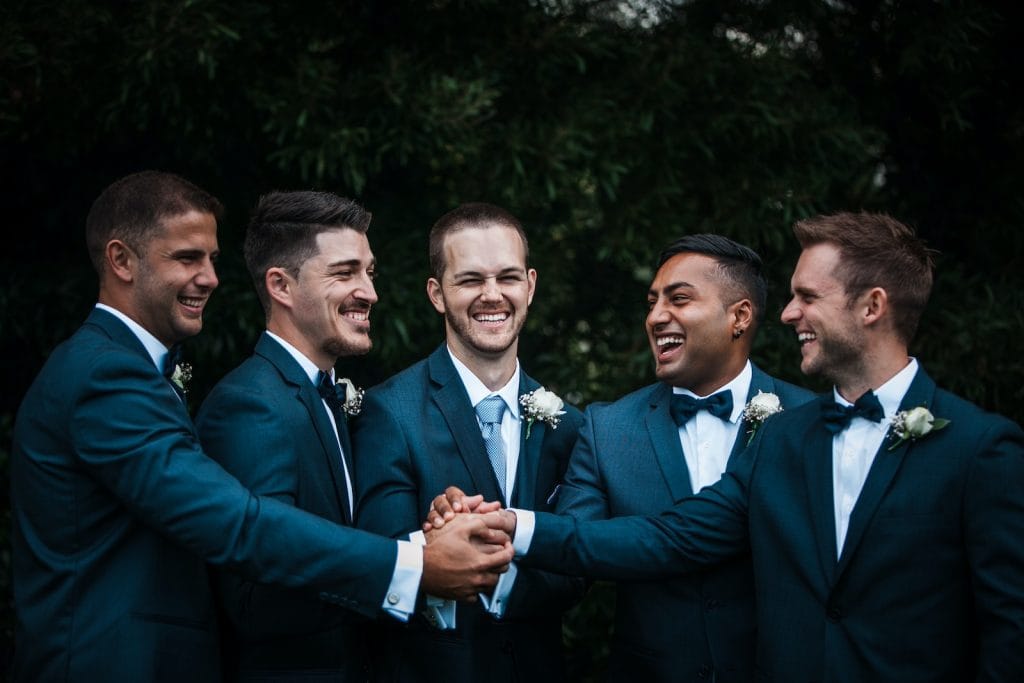 Happy groom with groomsmen on street