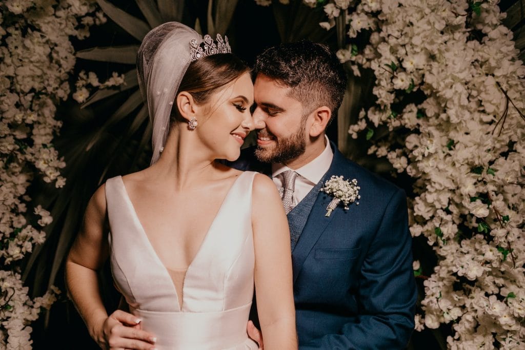 man in blue suit kissing woman in white sleeveless dress