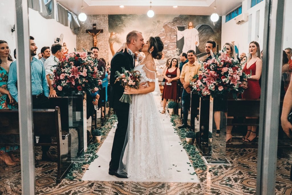 woman in white wedding gown standing on brown wooden stairs