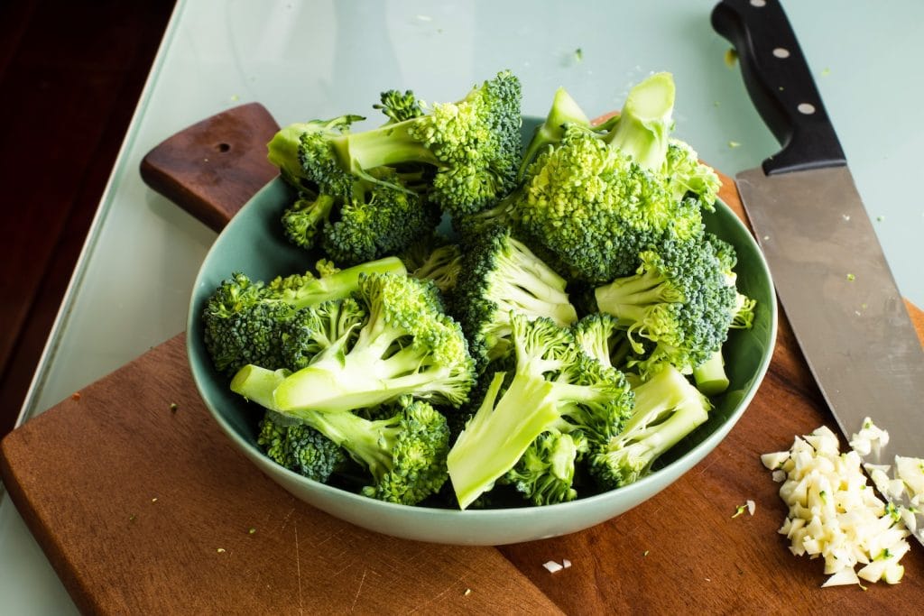 green broccoli on brown wooden chopping board