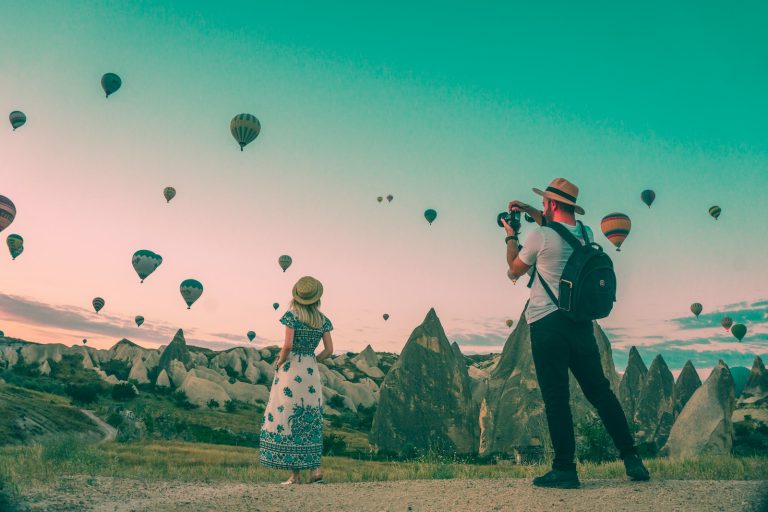 man taking photo of hot air balloons