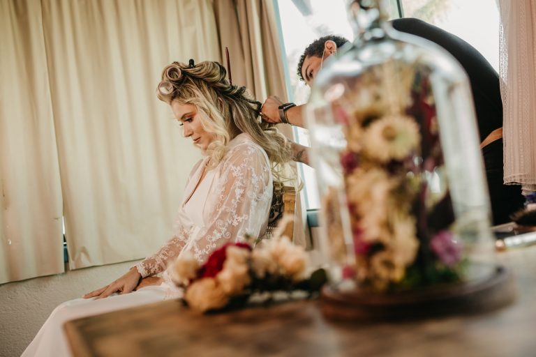 a woman getting her hair styled by a man