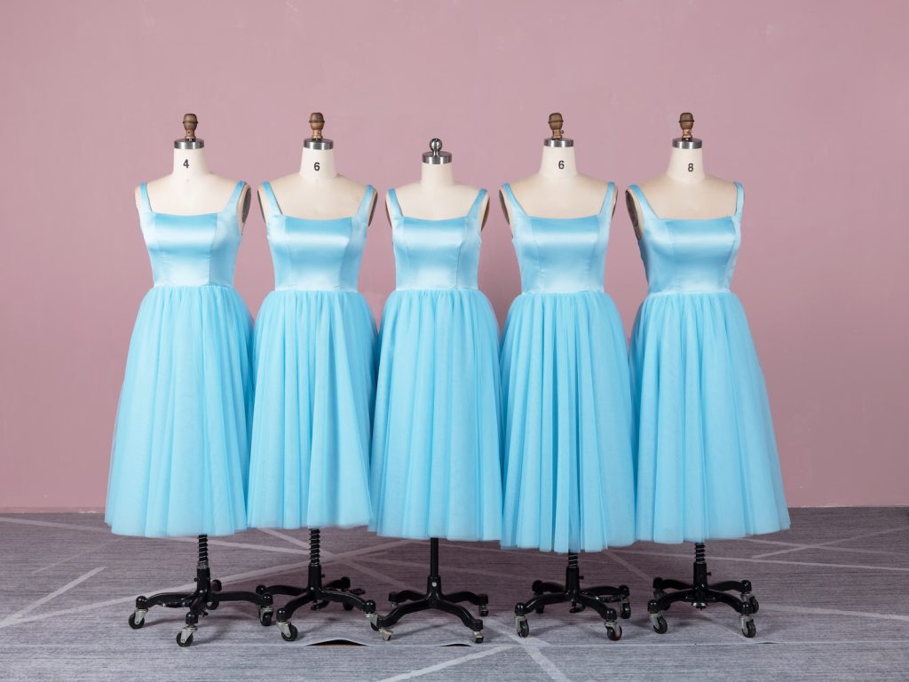 a line of blue bridesmaid dresses on mannequins