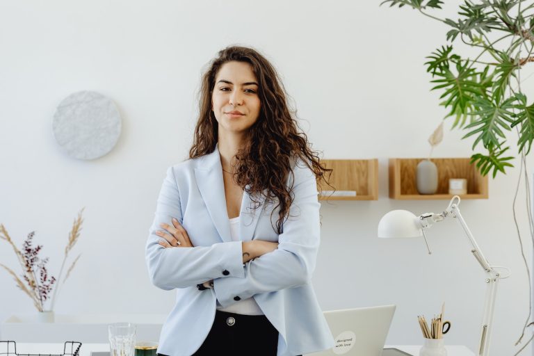 Woman in Sky Blue Blazer Standing Near White Wall