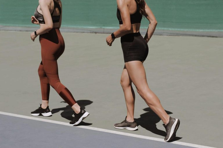 Women Running Together on the Athletic Field