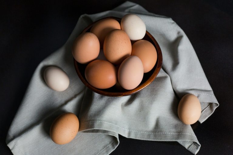 beige and white eggs on brown wooden bowl