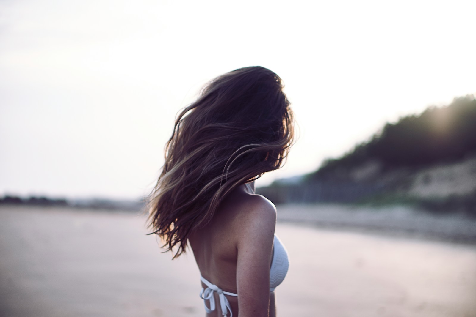 woman standing wearing white bra in selective focus photography