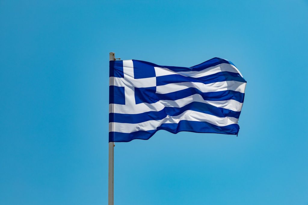 blue and white striped flag on pole under blue sky during daytime